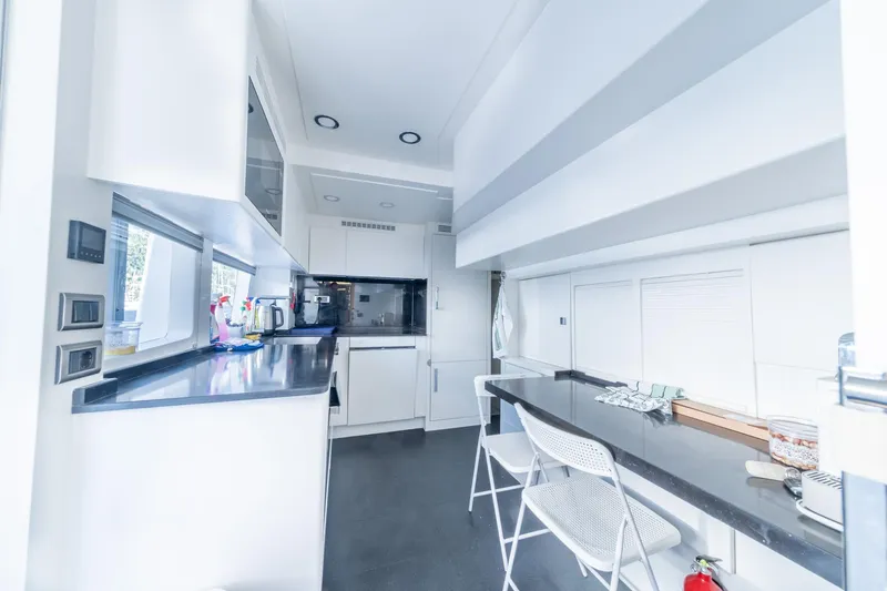  Yacht Photos Pics Modern kitchen interior on 2013 Benetti Delfino 93 yacht, featuring sleek countertops and white cabinetry.