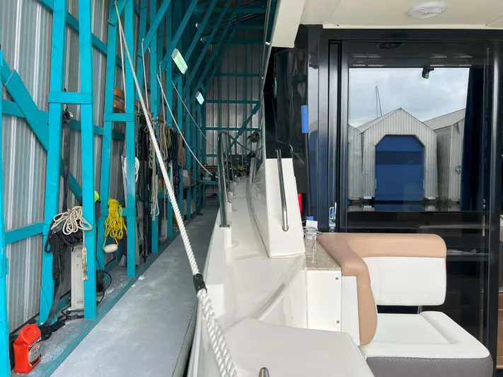 The Good Life Yacht Photos Pics 2018 Sea Ray 400 Sundancer docked in a marina with blue structural beams.