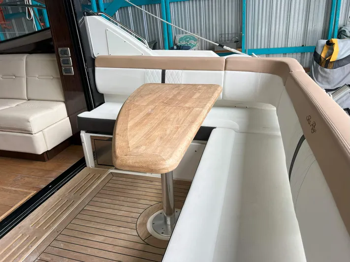 The Good Life Yacht Photos Pics 2018 Sea Ray 400 Sundancer interior with wooden table and white seating.