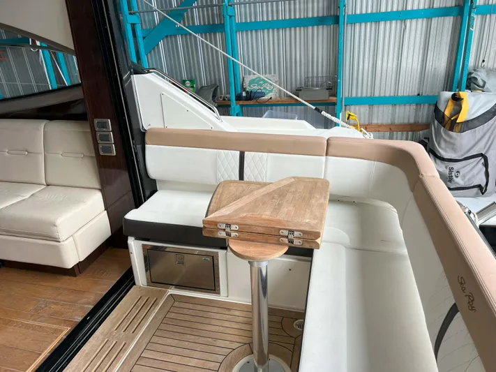 The Good Life Yacht Photos Pics 2018 Sea Ray 400 Sundancer interior with seating and foldable wooden table.