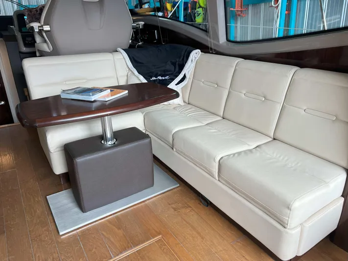 The Good Life Yacht Photos Pics Luxurious interior of 2018 Sea Ray 400 Sundancer with cream leather seating and wooden table.