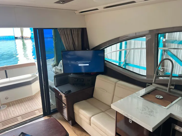 The Good Life Yacht Photos Pics Interior of 2018 Sea Ray 400 Sundancer yacht with sofa, TV, and kitchenette.