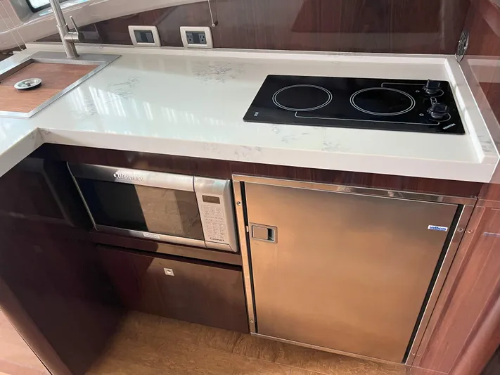 The Good Life Yacht Photos Pics Modern kitchen area in 2018 Sea Ray 400 Sundancer yacht with stove, microwave, and fridge.