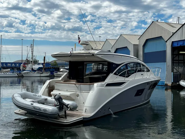 The Good Life Yacht Photos Pics 2018 Sea Ray 400 Sundancer yacht docked, featuring sleek design and attached inflatable boat.