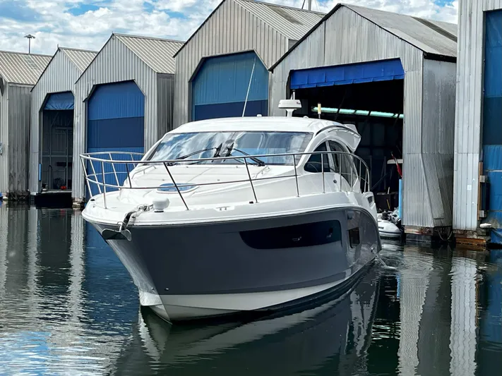 The Good Life Yacht Photos Pics 2018 Sea Ray 400 Sundancer yacht docked near boathouses on a calm waterway.