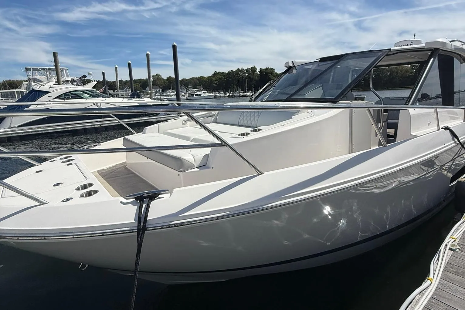 2021 Regal 36 Grande Coupe yacht docked at marina under clear sky.