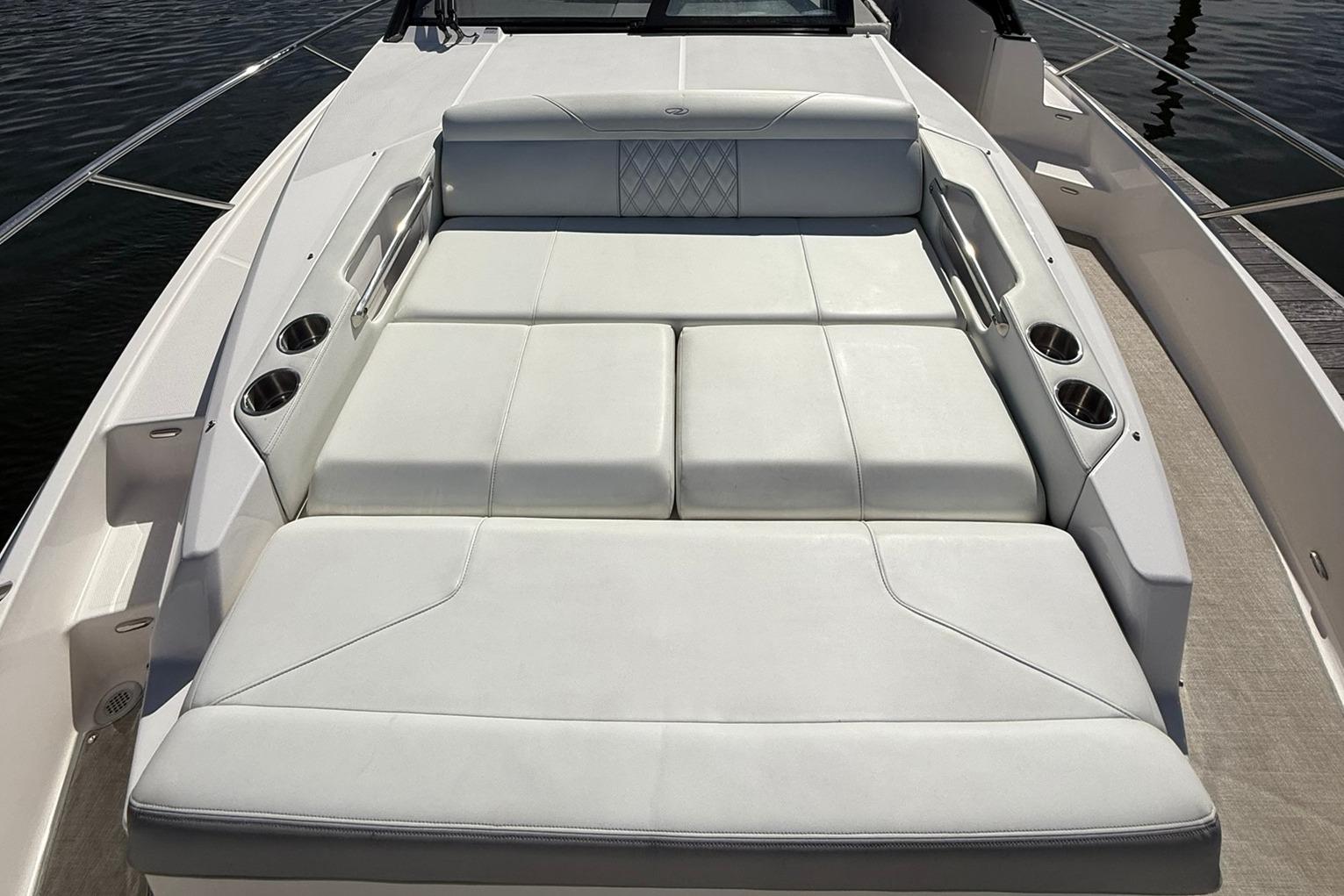 2021 Regal 36 Grande Coupe boat with spacious white sunbed and cup holders.