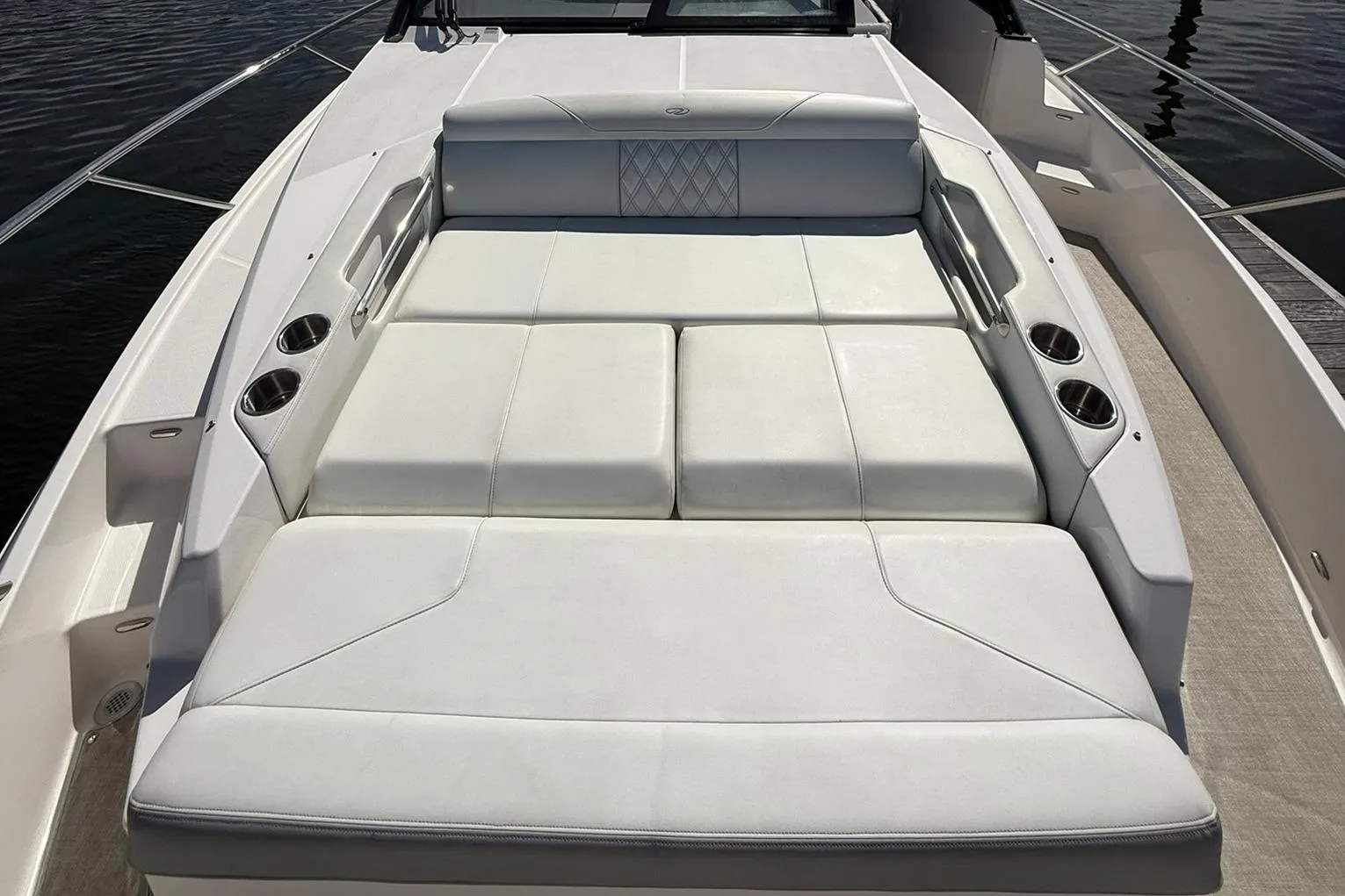 2021 Regal 36 Grande Coupe boat with spacious white sunbed and cup holders.