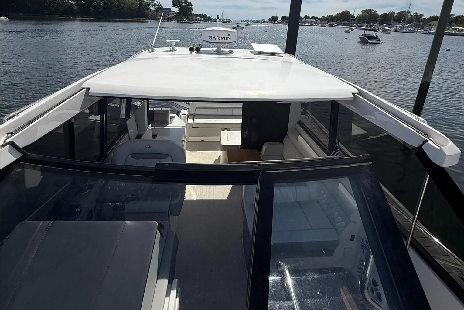 2021 Regal 36 Grande Coupe yacht interior with open roof, docked on a serene lake.