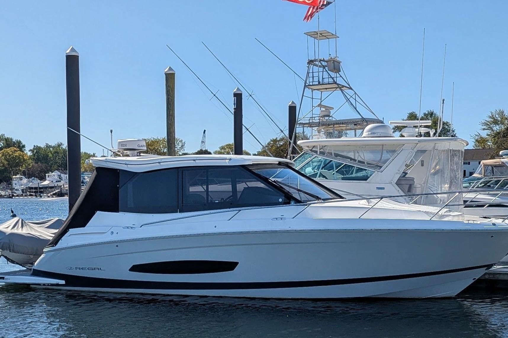 2021 Regal 36 Grande Coupe yacht docked at marina, side view.