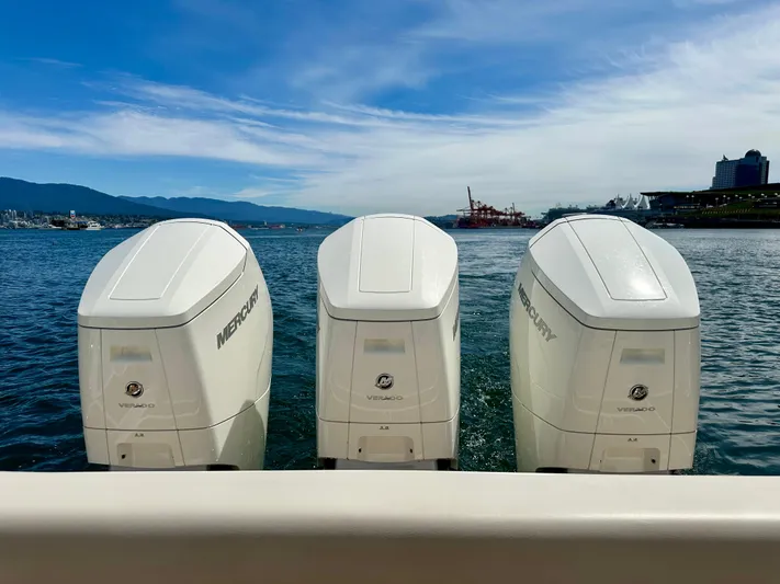 Blue Reeler Yacht Photos Pics Triple Mercury outboard engines on a 2023 Boston Whaler 405 Conquest, docked by the waterfront.