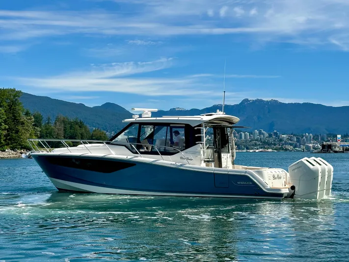 Blue Reeler Yacht Photos Pics 2023 Boston Whaler 405 Conquest boat on scenic water with mountains in background.