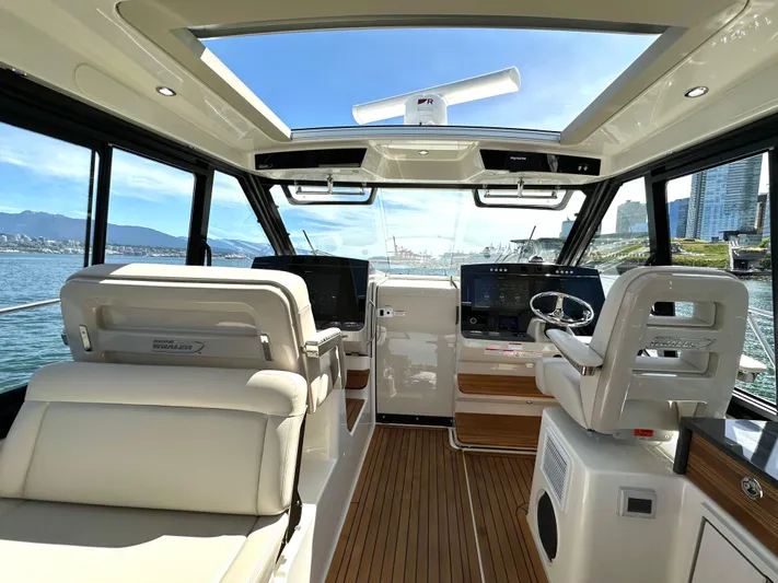 Blue Reeler Yacht Photos Pics 2023 Boston Whaler 405 Conquest interior with modern helm, luxurious seating, and panoramic windows.