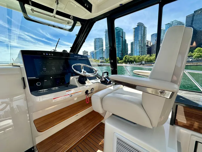 Blue Reeler Yacht Photos Pics 2023 Boston Whaler 405 Conquest helm with city skyline view, featuring modern controls and seating.