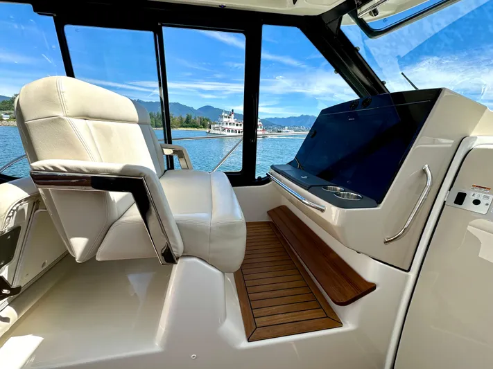 Blue Reeler Yacht Photos Pics 2023 Boston Whaler 405 Conquest helm with luxurious seating and modern controls, overlooking scenic waters.