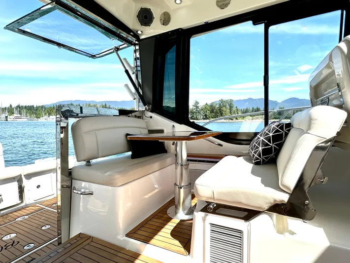 Blue Reeler Yacht Photos Pics 2023 Boston Whaler 405 Conquest interior with seating, table, and scenic water view.