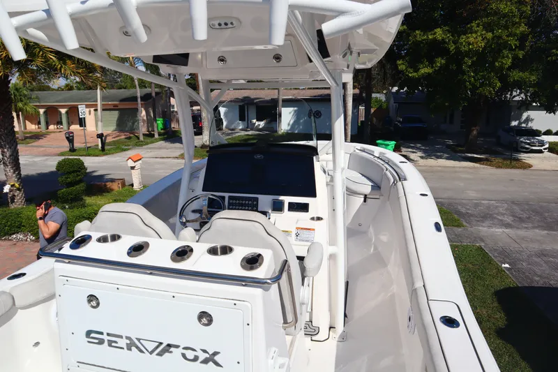  Yacht Photos Pics 2022 Sea Fox 288 Commander boat with helm, seating, and console in a residential area.