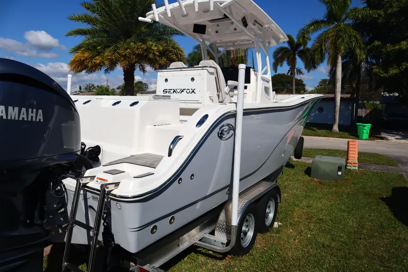  Yacht Photos Pics 2022 Sea Fox 288 Commander boat on trailer, parked outdoors with palm trees in background.