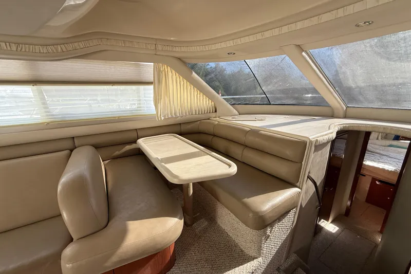  Yacht Photos Pics Interior of 1998 Sea Ray 480 Sedan Bridge with beige seating and dining table.