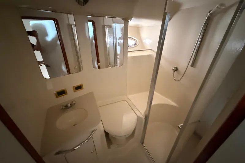  Yacht Photos Pics Bathroom interior of 1998 Sea Ray 480 Sedan Bridge yacht, featuring shower and vanity.