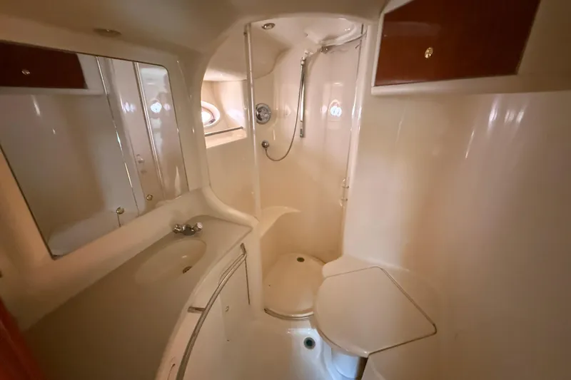  Yacht Photos Pics Bathroom interior of 1998 Sea Ray 480 Sedan Bridge yacht, featuring shower and sink.