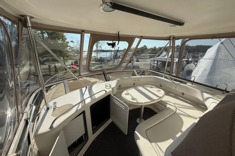  Yacht Photos Pics 1998 Sea Ray 480 Sedan Bridge interior with seating and table, overlooking marina.