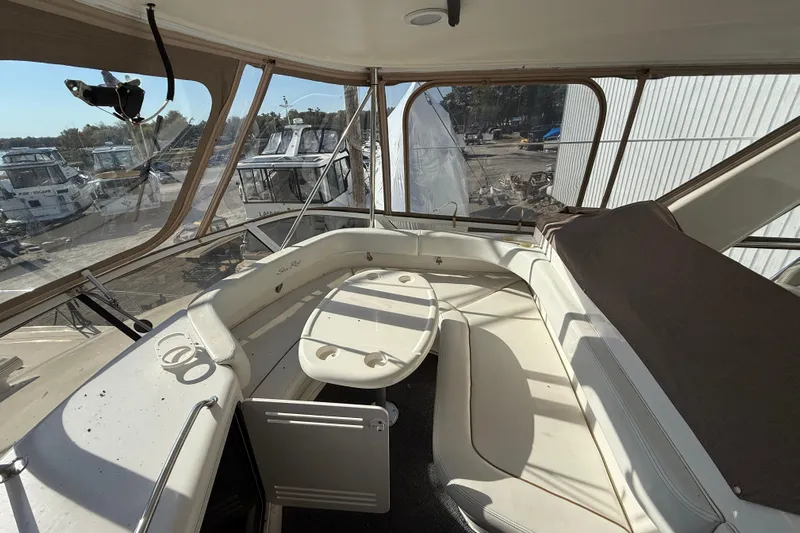  Yacht Photos Pics 1998 Sea Ray 480 Sedan Bridge interior with seating and table, marina view.