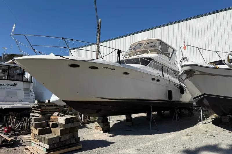  Yacht Photos Pics 1998 Sea Ray 480 Sedan Bridge yacht on dry dock, side view, clear sky background.