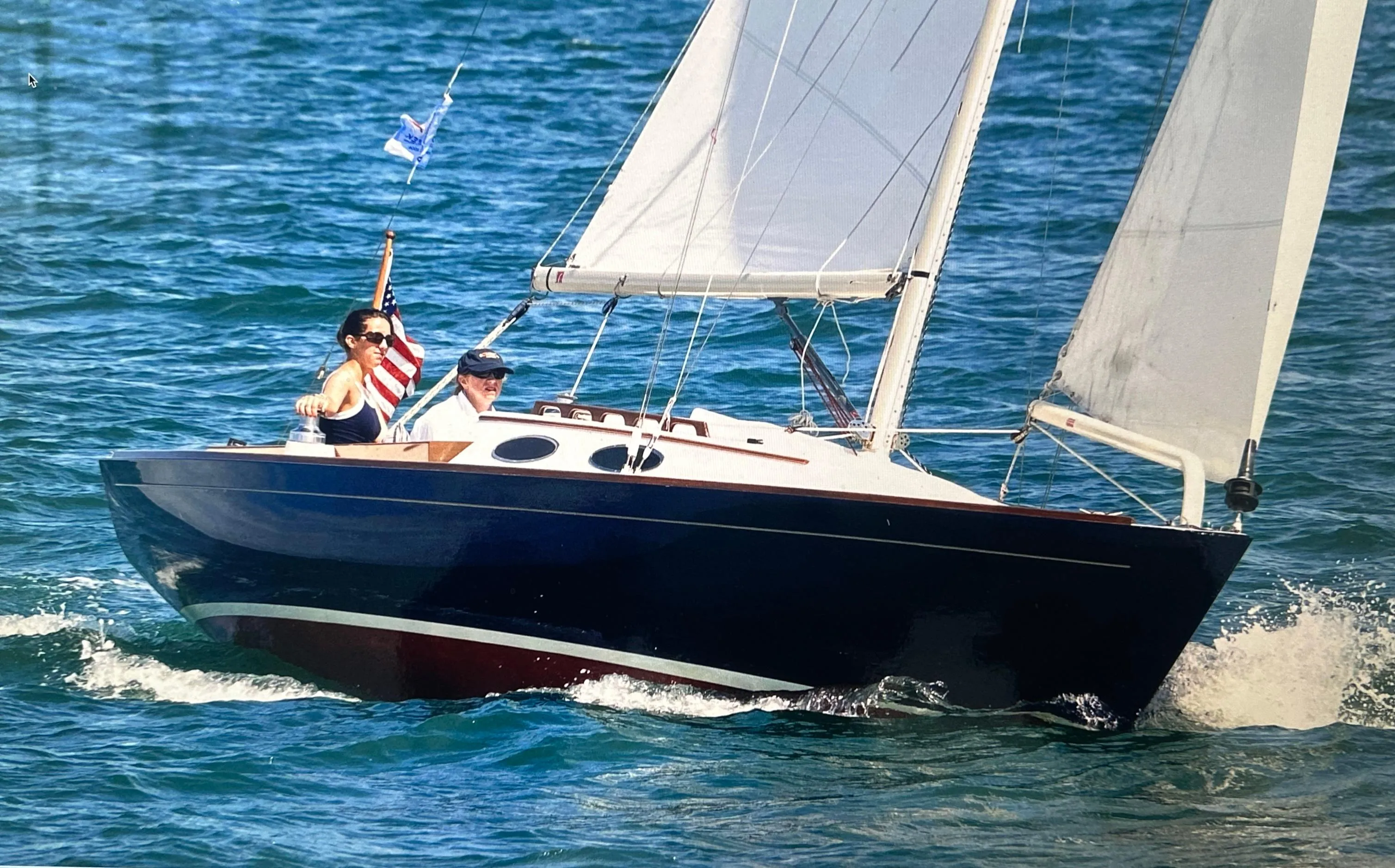 2002 Alerion Express 28 sailboat cruising on blue ocean waters.