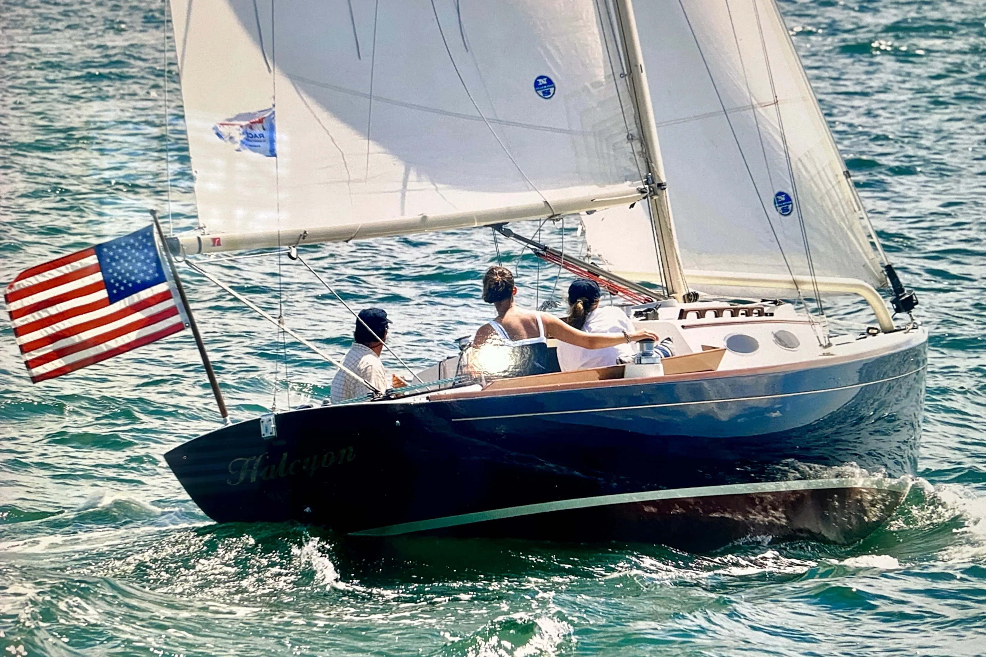 Alerion Express 28 sailboat from 2002 sailing with American flag on open water.