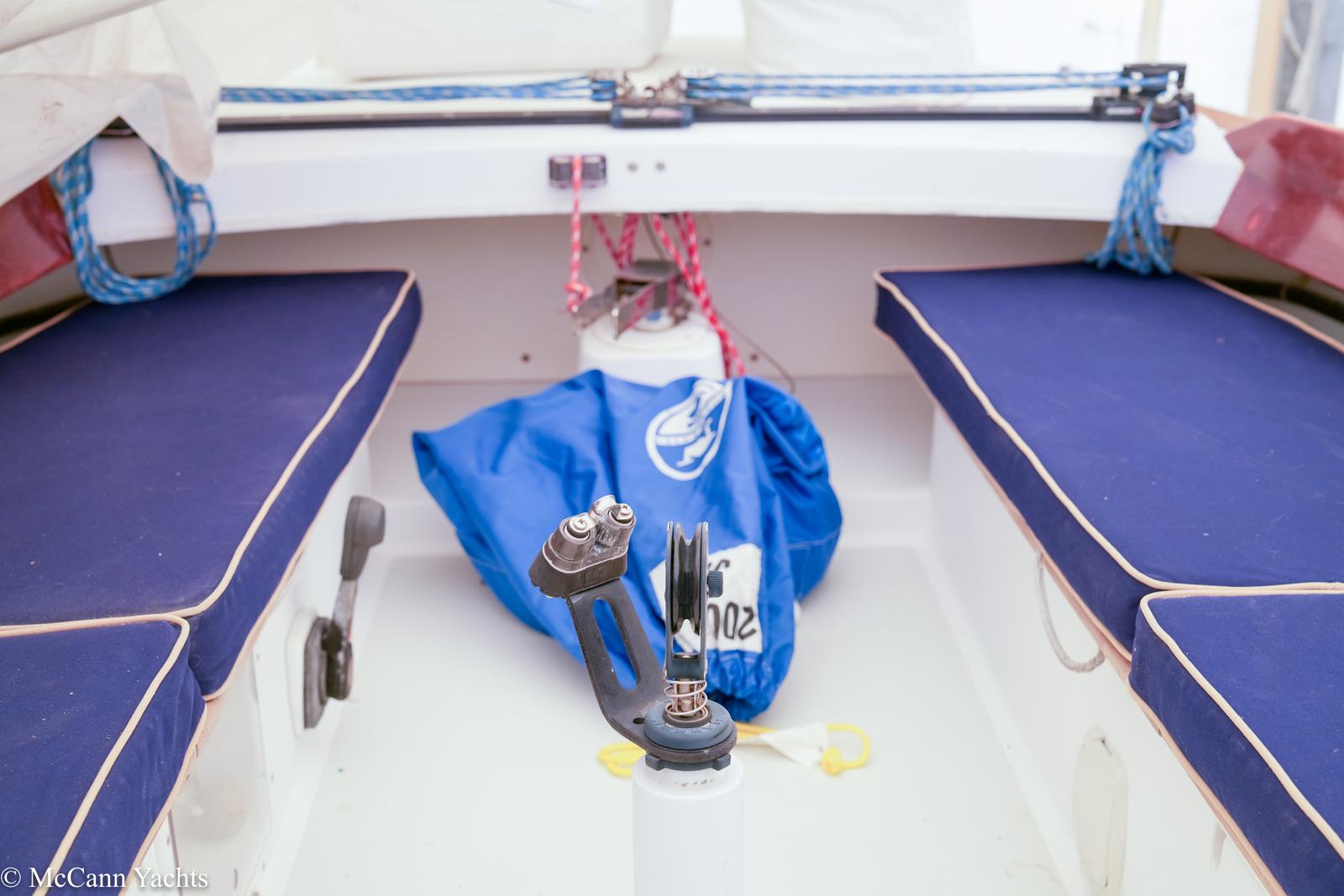 Interior of a 2002 Alerion Express 28 sailboat with blue seating and nautical equipment.