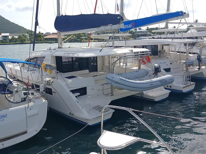 Red Robin Yacht Photos Pics 2019 Leopard 40 catamaran docked with dinghy, surrounded by other boats.