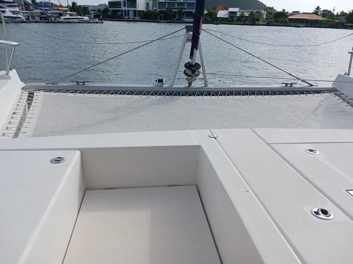 Red Robin Yacht Photos Pics Leopard 40 catamaran deck with netting, 2019 model, docked by waterfront homes.