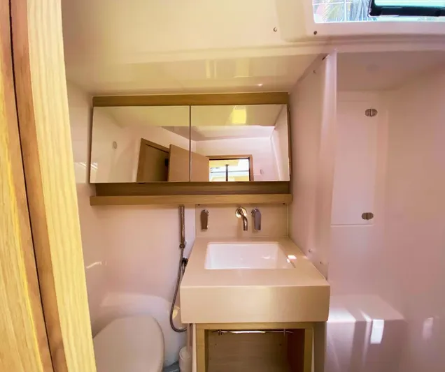 Dufour 530 In Annapolis Yacht Photos Pics Modern bathroom in 2024 Dufour 530 yacht with sink, mirror, and toilet.