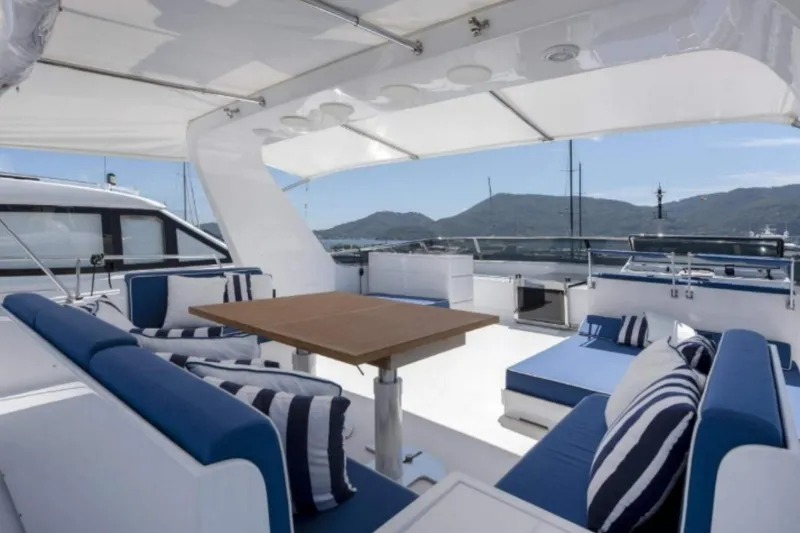  Yacht Photos Pics Luxurious 1995 Codecasa 24 yacht deck with blue seating and scenic mountain view.