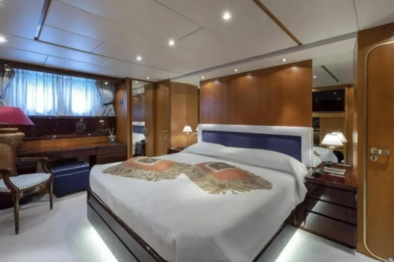  Yacht Photos Pics Luxurious bedroom interior on a 1995 Codecasa 24 yacht, featuring elegant wood paneling and ambient lighting.