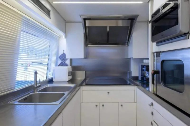 Yacht Photos Pics Modern kitchen interior in a 1995 Codecasa 24 yacht, featuring stainless steel appliances and sleek design.