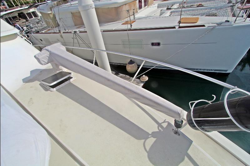 1994 Bertram 50 Convertible yacht deck with covered equipment, docked beside another boat.
