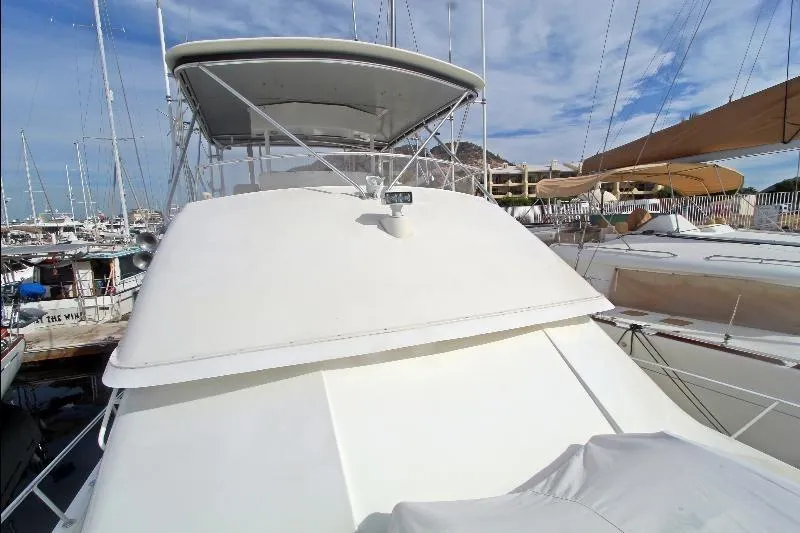  Yacht Photos Pics 1994 Bertram 50 Convertible yacht docked in a marina under a clear blue sky.