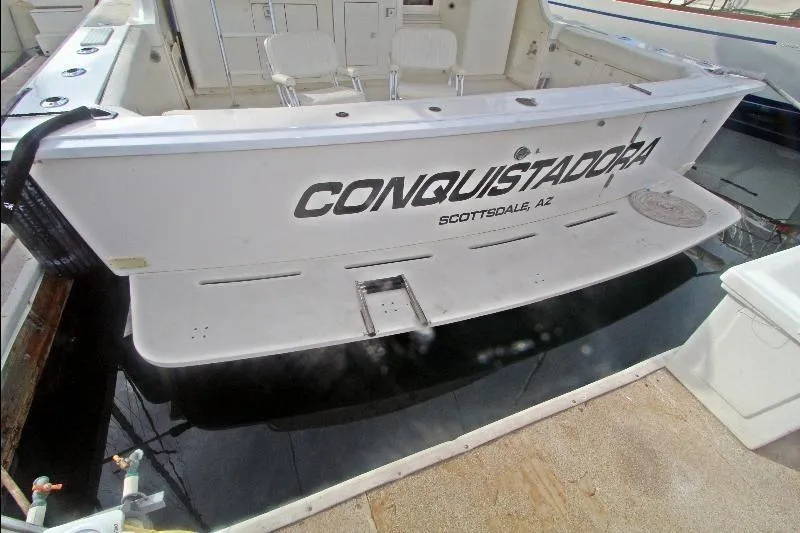  Yacht Photos Pics 1994 Bertram 50 Convertible yacht named "Conquistadora" docked, rear view with seating area.