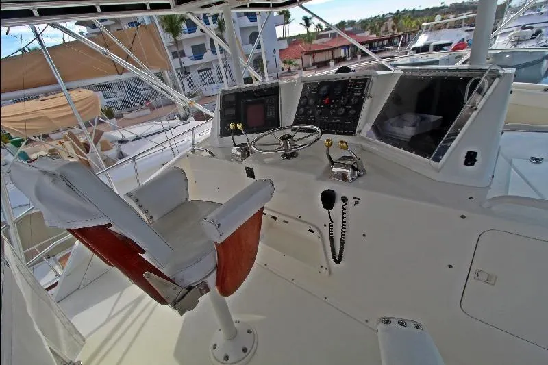  Yacht Photos Pics Cockpit of a 1994 Bertram 50 Convertible yacht with steering wheel and control panel.