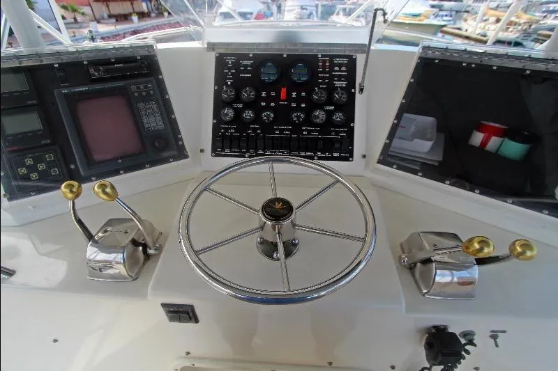  Yacht Photos Pics Control panel of a 1994 Bertram 50 Convertible yacht with steering wheel and gauges.