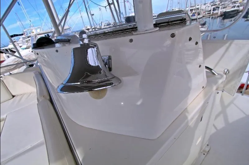  Yacht Photos Pics 1994 Bertram 50 Convertible yacht with chrome bell, docked in marina.