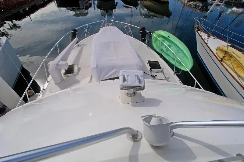  Yacht Photos Pics 1994 Bertram 50 Convertible yacht deck view with covered equipment, docked in marina.