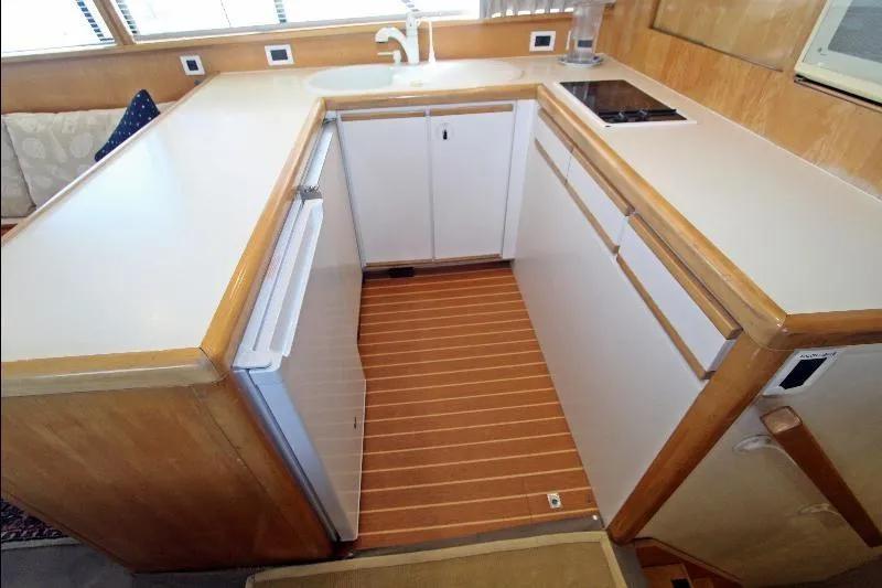  Yacht Photos Pics 1994 Bertram 50 Convertible yacht kitchen with white cabinets and wood accents.