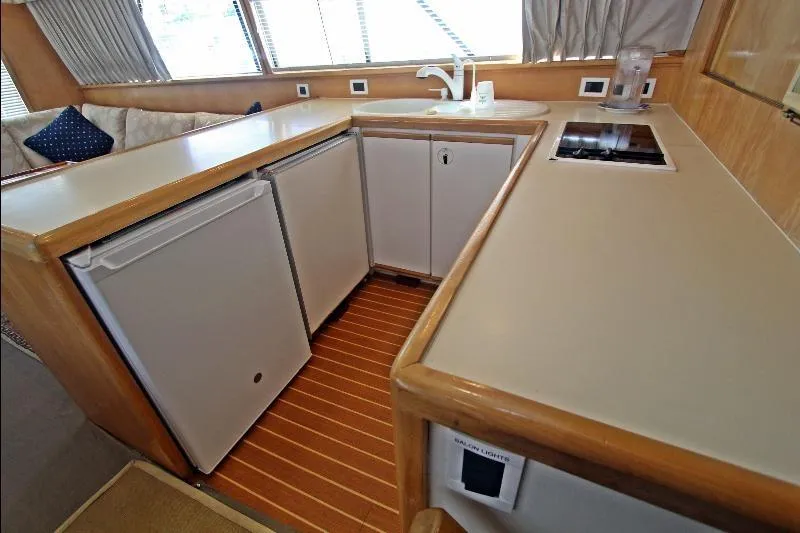  Yacht Photos Pics 1994 Bertram 50 Convertible yacht kitchen with modern appliances and wood flooring.