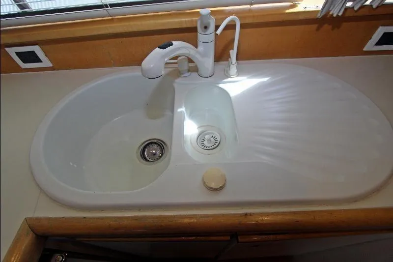  Yacht Photos Pics Kitchen sink on a 1994 Bertram 50 Convertible yacht, featuring dual basins and modern faucet.