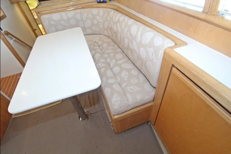  Yacht Photos Pics 1994 Bertram 50 Convertible interior with cushioned seating and white table.