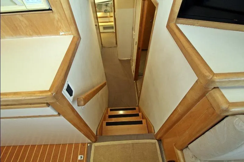  Yacht Photos Pics Interior view of 1994 Bertram 50 Convertible yacht, featuring wooden stairs and hallway.