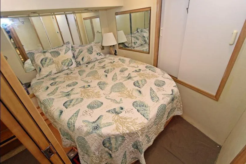  Yacht Photos Pics Cozy bedroom in 1994 Bertram 50 Convertible yacht with seashell-themed bedding.